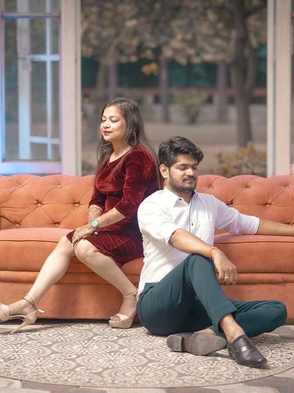 A stylish and moody pre-wedding shot with the couple posing on and around a vintage sofa in a beautiful indoor-outdoor setting.