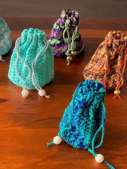 These colorful potli bags are perfect for gifting or as a cute accessory. Each drawstring pouch is made with vibrant, multi-tonal yarn, making every piece unique.