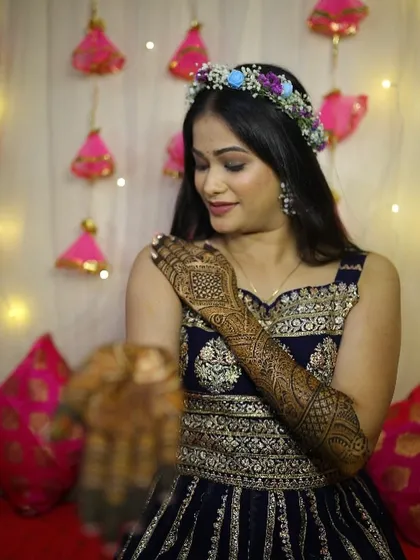 Admiring the intricate Mehendi design. The bride's simple makeup and floral hairband ensure that the focus remains on the beautiful henna art.