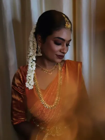 An artistic shot of a dusky bride. The soft focus and warm lighting highlight the rich undertones of her skin and the beautiful matte finish of the makeup.