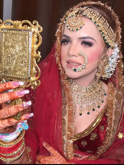 Pure elegance. This bride looks like royalty, admiring her reflection in a mirror, wearing a heavy polki and black bead set.