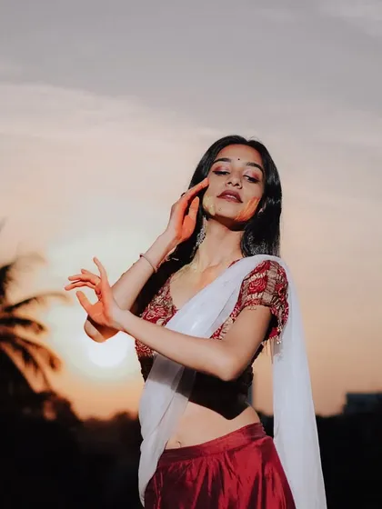 A graceful pose during a Holi-themed shoot, with the warm light of the setting sun creating a beautiful silhouette.