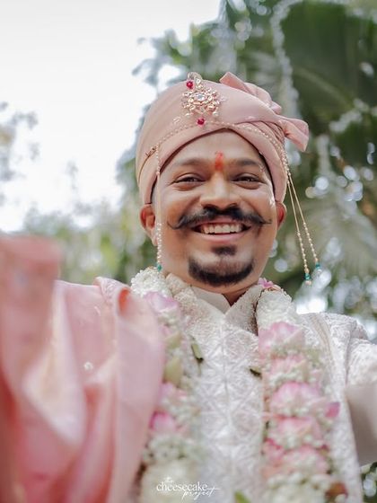 A fun, interactive shot of the groom reaching out to the camera during his baraat.