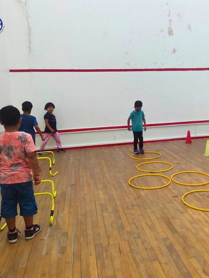 An agility drill using hurdles and hoops. These exercises are excellent for developing coordination, speed, and motor skills in young children.