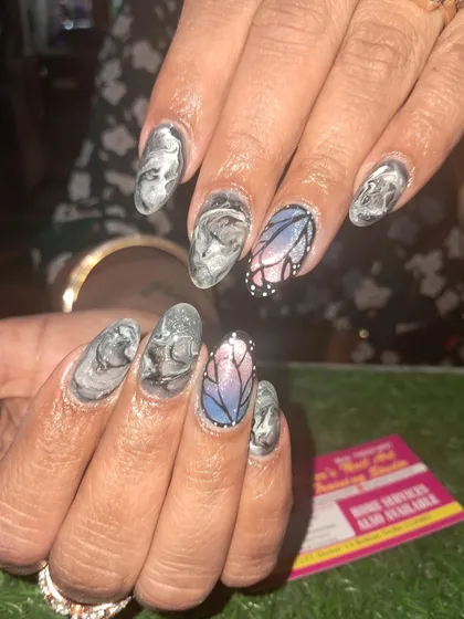 A unique and artistic set combining a grey marble effect with a stunning, stained-glass style butterfly accent nail. This shows how we can mix different art styles in one set.
