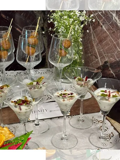 Bite sized delights served in style. We use martini glasses and wine glasses to present our appetizers, like these dahi bhalla cups and savory skewers, adding a touch of sophistication.