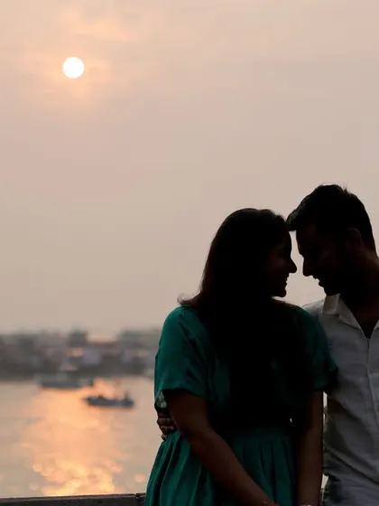 A romantic silhouette of a couple against the setting sun over the water. This style of pre-wedding photography creates a soft, intimate mood, focusing on the connection between the two of you.