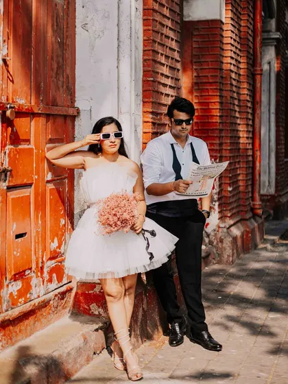 The color version of our editorial-style shot. The vibrant red door in the background adds a pop of energy and passion to the couple's cool and collected poses.