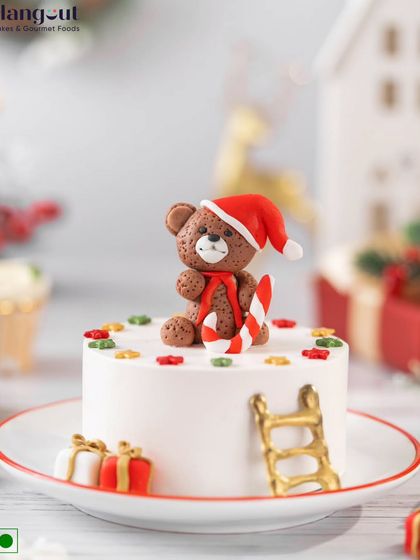 This festive Black Forest Bento Cake is a delight, with layers of chocolate, cream, and cherries. It's topped with an adorable teddy bear in a Santa hat, making it a perfect Christmas treat.