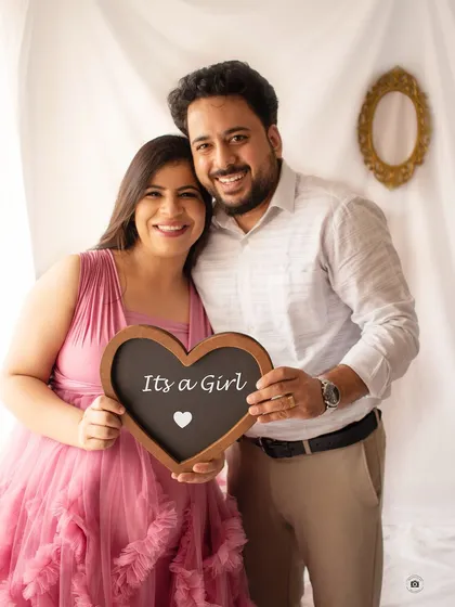 A happy "It's a Girl!" announcement. This classic portrait captures the couple's joy and excitement as they look forward to meeting their daughter.