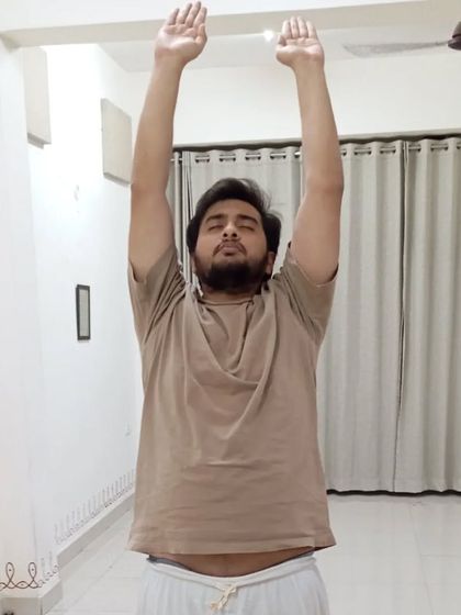 A participant raises his arms in the initial phase of Surya Kriya, preparing to connect with the solar energy.
