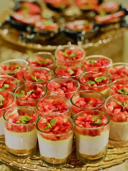 Strawberry cheesecake parfaits layered in glass cups. The vibrant red of the fresh strawberries makes this a visually appealing and refreshing dessert.
