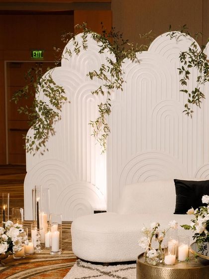 The stunning, modern decor at the wedding reception. The clean lines and white color palette of the backdrop create a chic and sophisticated atmosphere.