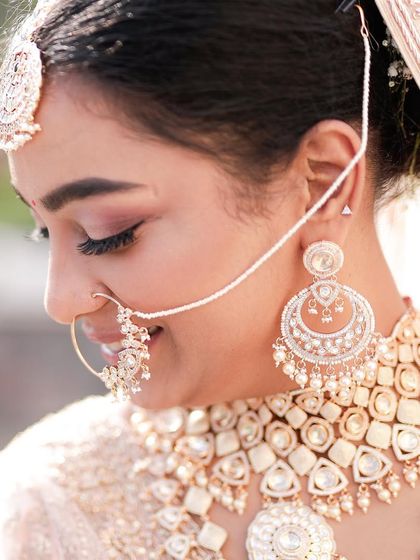 A side profile of our morning bride, showcasing the elegant floral bun and the flawless, dewy skin finish.