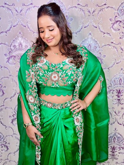 This look is serving main character energy. I created a soft glam look with defined eyes and a radiant finish to complement her vibrant green outfit.