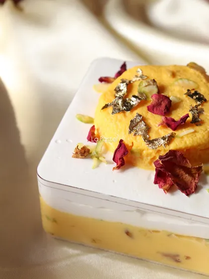 This is my signature Rasmalai Tres Leches tub. It's a fusion dessert that combines the classic Indian sweet with a soft, milky cake, topped with edible gold leaf and rose petals.
