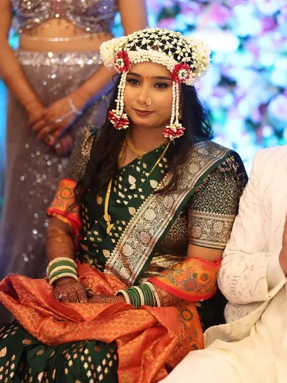 A unique look for an engagement ceremony, featuring a beautiful floral mundavalya. The makeup is kept fresh and glowing to match the celebratory mood.