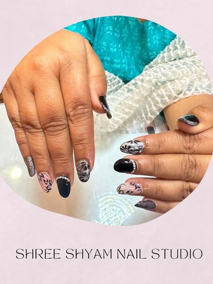 A stylish mix of cat-eye, animal print, and solid black nails with rhinestone borders.
