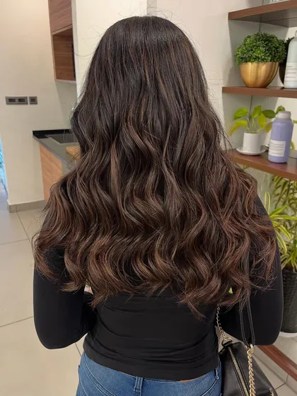 A full back view showcasing the length and health of the hair after the coloring and styling service.