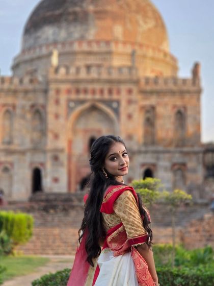 A classic over the shoulder pose with the iconic Lodi Garden tomb in the background. This shot beautifully combines the subject's grace with the location's heritage for a perfect ethnic portrait.