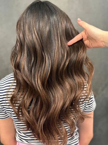 A stylist pointing to the highlights, showcasing the detailed work.