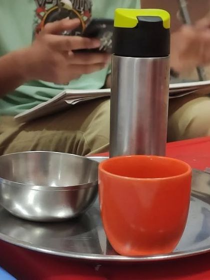 A different angle of the still life reference, showing a steel flask, a bowl, and a cup. We use common household items to make our lessons relatable and accessible.