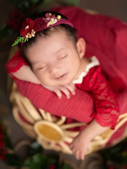 A sweet smile from a baby dressed in a lovely red lace outfit. I have a wide selection of outfits in various colors and styles for your session.