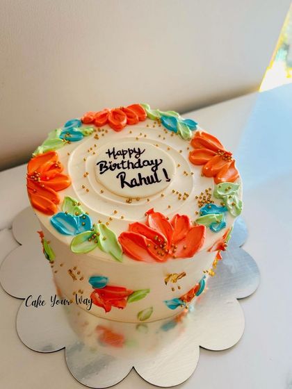 A simple, elegant cake with colorful painted flowers.