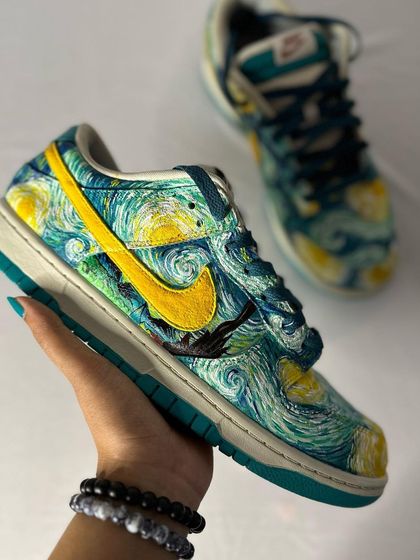 Holding up the "Starry Night" custom Nike Dunks. The texture of the brushstrokes mimics Van Gogh's original painting.