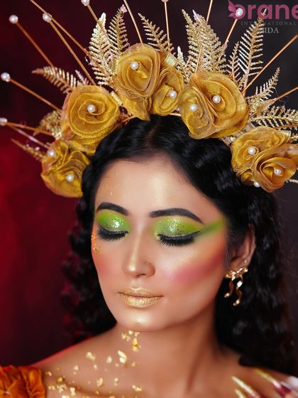 A detailed close-up of the sparkling green eyeshadow and the golden lips.