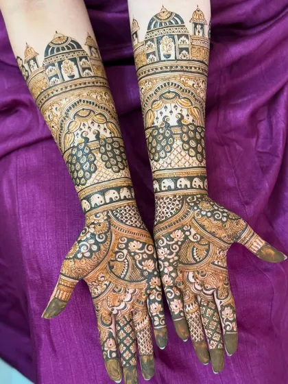 I love creating perfectly symmetrical bridal designs like this one. It features palace architecture, dancing peacocks, and tiny elephants, all woven together to create a story on the bride's arms.