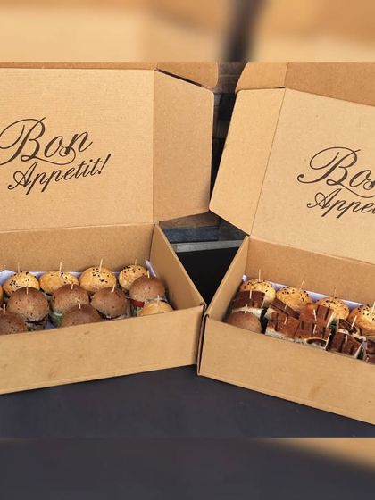 Bon Appétit! Our canapé boxes are filled with a selection of bite-sized culinary delights, like these mini burgers and sandwiches, perfect for elevating any occasion.
