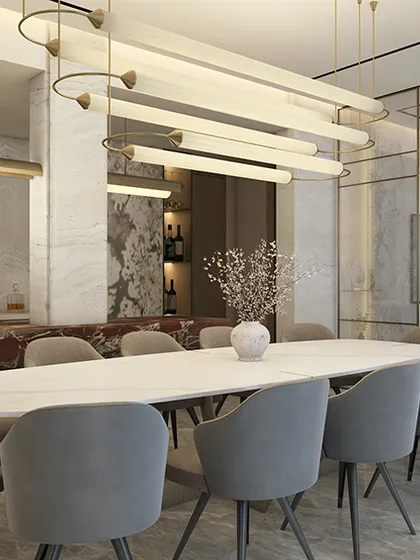 In this sky-high dining room, finesse meets warmth. The space balances sleek lines with tactile materials, featuring a stunning red marble cantilevered bar against a backdrop of lighter natural stone, creating an atmosphere that is both sophisticated and inviting.