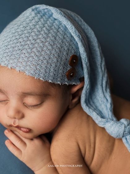 A close-up to cherish, focusing on the baby's sweet face and the texture of the knitted blue bonnet.