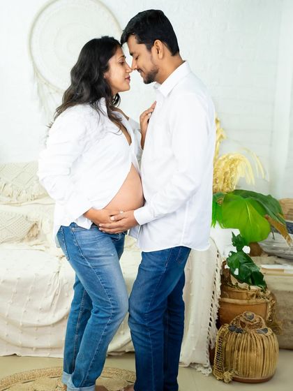 A casual and sweet moment. Dressed in matching white shirts and jeans, this couple shares an intimate nose-to-nose pose in our bright and airy studio.