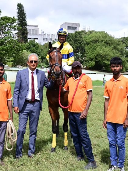 Mandarino, winner of The Stewards Cup, with jockey A. Sandesh and the winning connections.