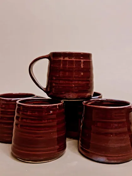 A collection of my rich, burgundy-glazed mugs and tumblers. Each piece is a unique work of art, perfect for elevating your morning routine with a touch of handmade beauty.