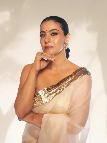 A thoughtful pose that brings attention to the oversized stud earrings and the delicate texture of the saree.