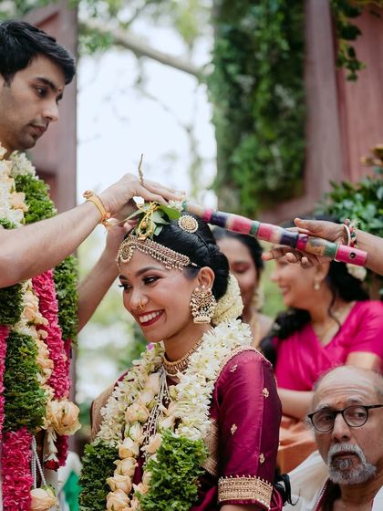 A sacred moment during the wedding ceremony, as the groom performs a ritual with family looking on.