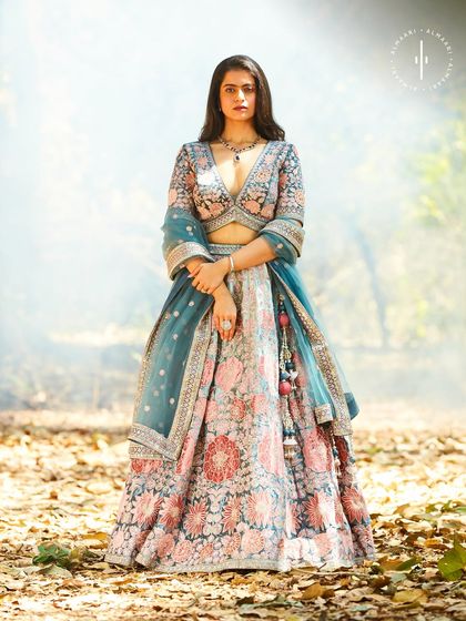 This floral lehenga with a contrasting teal dupatta is a masterpiece of color and embroidery. It's a sophisticated choice for any wedding guest wanting to stand out.