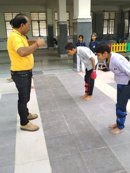 Respect is the first lesson. Two students bow to their instructor before beginning a drill, a core tradition in martial arts that teaches humility and discipline.
