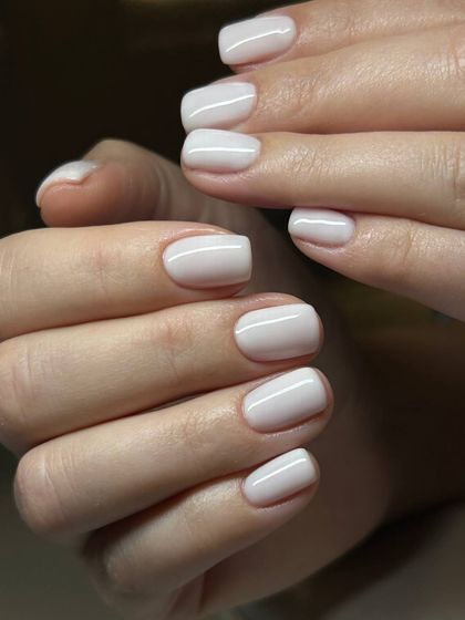 A clean, opaque white manicure on short, natural nails. This look is fresh, modern, and impeccably executed.