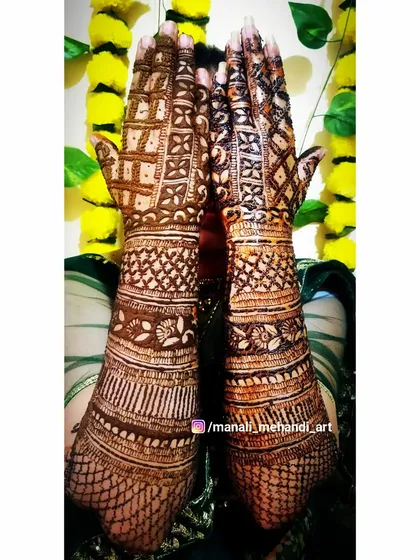 The back of a bridal mehandi design, showcasing dense checkerboard and jaal patterns. This full-coverage look is very popular with brides who want a rich and traditional feel.