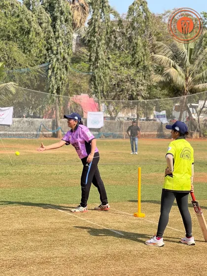 A female bowler delivers a tennis ball with precision during a PPL game.