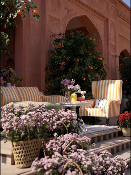 A cozy lounge nook from the "Art Day Out" brunch. The yellow and white striped chairs, set against the terracotta walls and orange trees, created a vibrant, Mediterranean feel.
