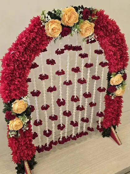 A vibrant and traditional small arch, perfect for home pujas. The red and yellow combination is classic and festive.