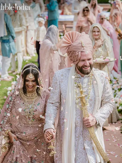 A joyful shot of the couple walking down the aisle after their ceremony, featured by Incredible India.