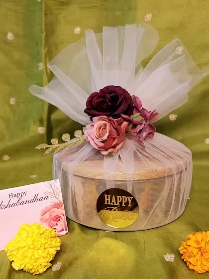 Sometimes, the beauty is in the wrapping. This simple yet elegant Rakhi gift is wrapped in sheer tulle with a floral accent, making the unboxing experience a delight.