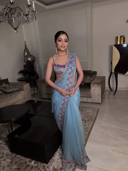 A full-length shot of the client in a beautiful light blue saree, her makeup adding the perfect touch of glamour.