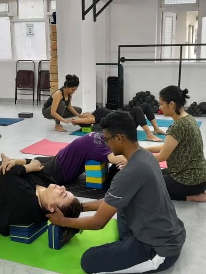 After an intense practice, we guide students into restorative poses. Here, a teacher provides a gentle neck release, helping to relieve tension and promote relaxation.